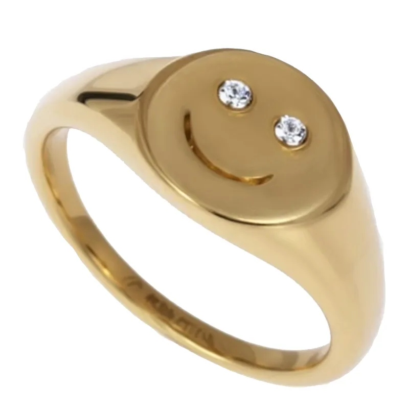 A screenshot of a real ring. A gold ring features a smiley face design on top, with two small diamonds set as the eyes.